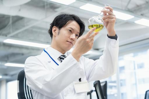 実験をする白衣の若い男性研究者 実験をする白衣の若い男性研究者 研究,実験,サイエンスの写真素材