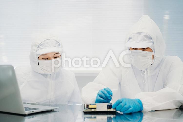 クリーンルームで精密機器を扱う女性 工場,クリーンルーム,製造業の写真素材