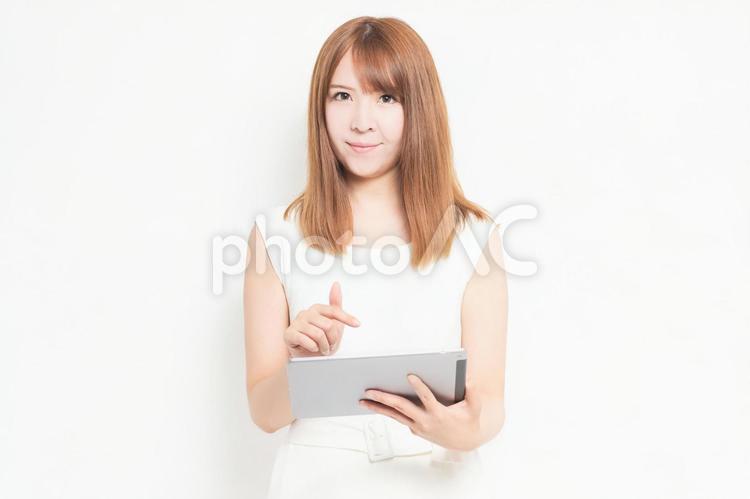 タブレット端末を使うワンピースを着た女性 女性,タブレット,snsの写真素材