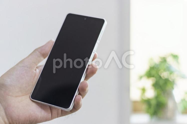 スマートフォンを持つ男の手（30代 手,スマートフォン,携帯電話の写真素材