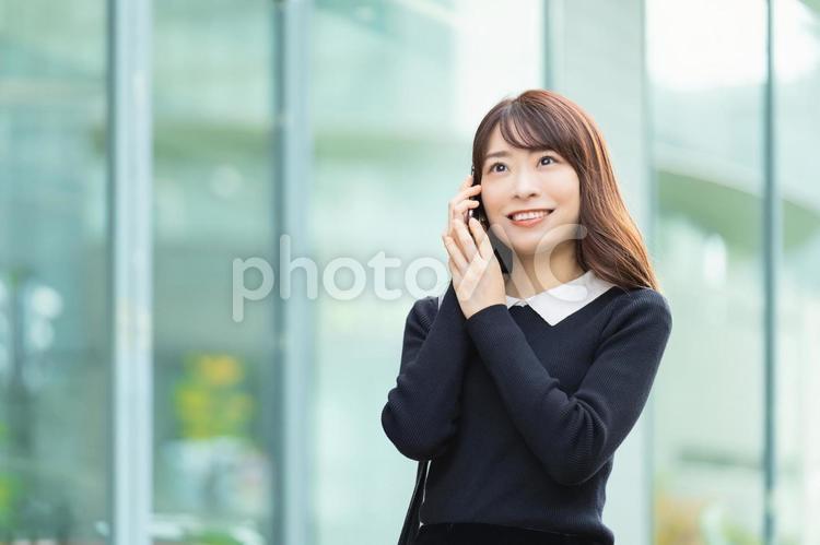スマホで通話をする笑顔のビジネスウーマン 女性,ビジネス,スマホの写真素材