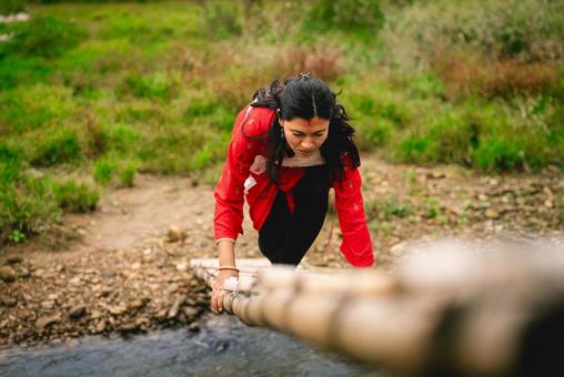 竹橋で川を渡るネパール人女性 ネパール,女性,ティカの写真素材