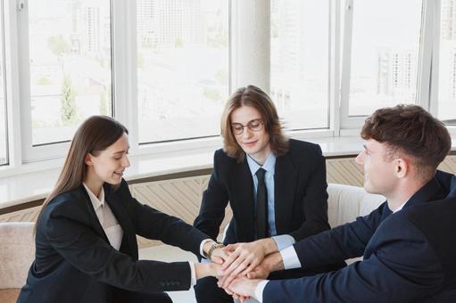 窓際で手を重ねた外国人男女 男女,外国人,ビジネスの写真素材