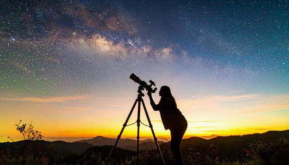 夏の夜空を望遠鏡で見る人のシルエット 夏の夜空を望遠鏡で見る人のシルエットの写真
