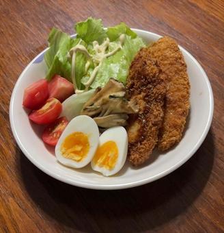 魚のフライと半熟卵と舞茸バター醤油炒め等 魚のフライと半熟卵と舞茸バター醤油炒め等の写真