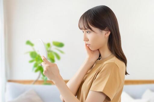 鏡で肌をチェックする若い女性 女性,美容,健康の写真素材