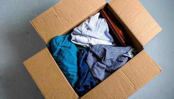 段ボール箱に入れた衣類と本と額縁 段ボール箱に入れた衣類と本と額縁の写真
