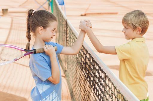 ラケットを持った女の子と握手する男の子 男女,子供,外国人の写真素材