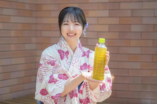 笑顔でお茶を出す女性 笑顔でお茶を出す女性 浴衣,女性,夏の写真素材