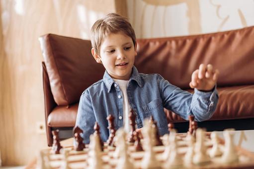 ソファテーブルでチェスをする男の子 ソファテーブルでチェスをする男の子の写真