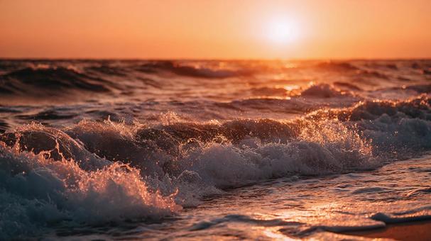 砕け散る波と燃えるような朝焼けの海 砕け散る波と燃えるような朝焼けの海の写真