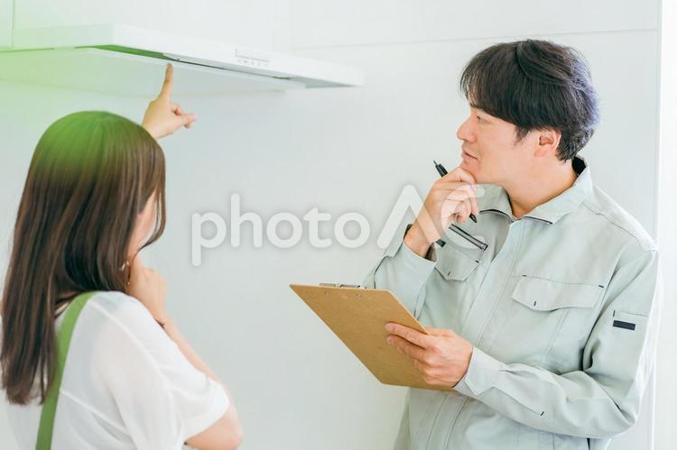 作業着姿の男性と女性（換気扇・クレーム） 換気扇,レンジフード,換気扇カバーの写真素材