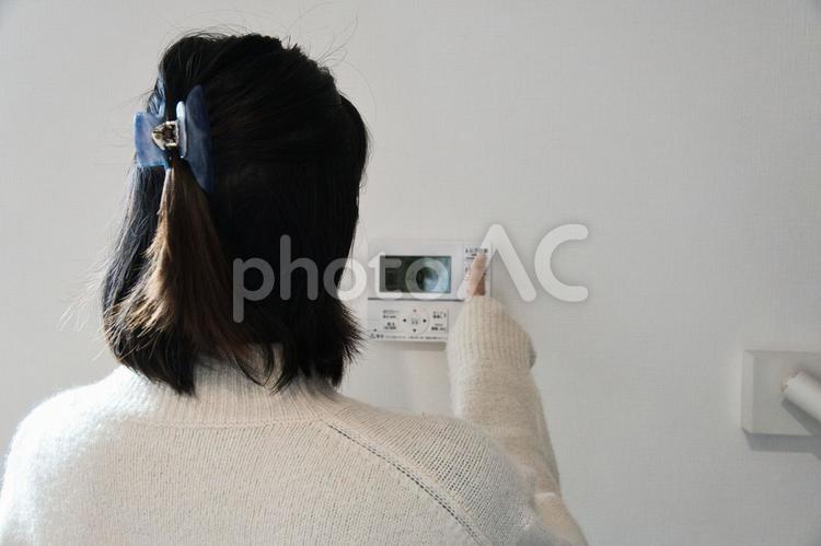 給湯機を操作してお風呂にお湯をはる女性 女性,顔なし,給湯機の写真素材