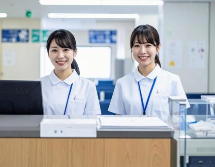 病院の受付コーナーで笑顔で迎える受付嬢 病院の受付コーナーで笑顔で迎える受付嬢の写真