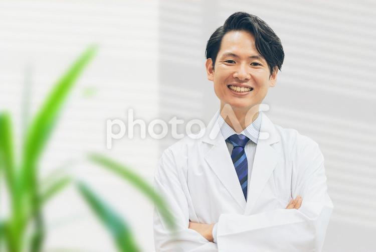 笑顔で腕組みをする医療スタッフの男性 男性,医療,人物の写真素材