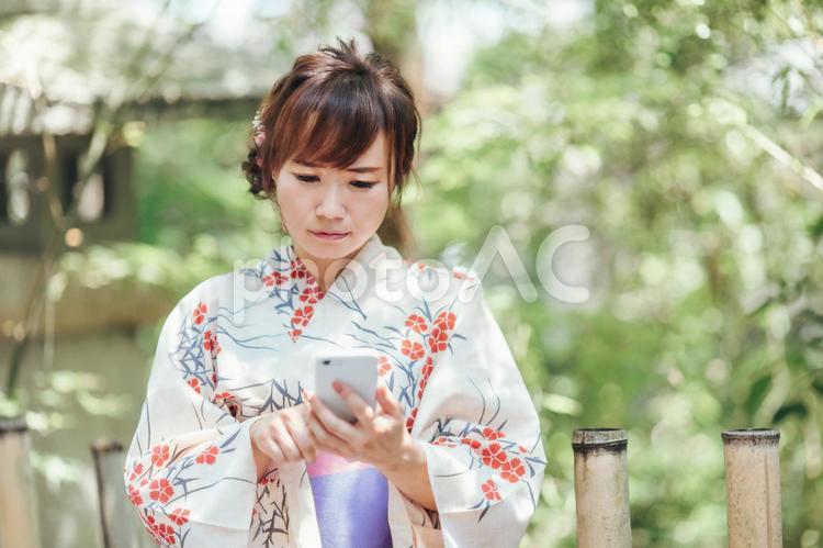 スマホを使う浴衣姿の女性（困る・悩む） 浴衣,スマホ,アプリの写真素材