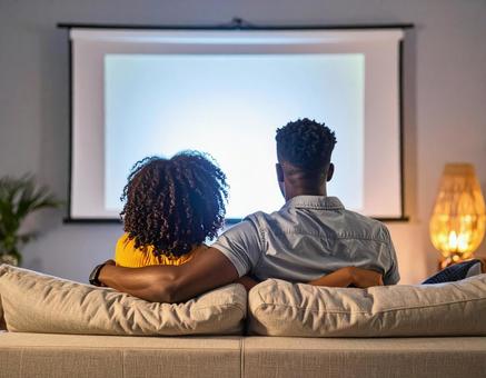 ホームシアターを楽しむカップル ホームシアターを楽しむカップルの写真