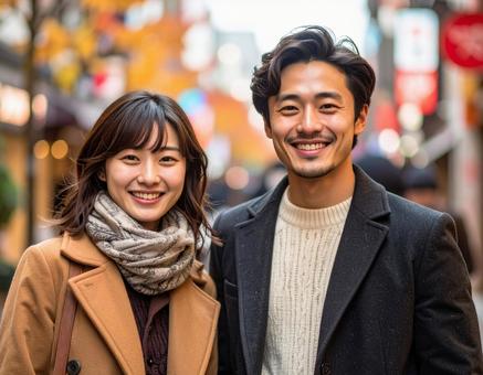 色づく街路樹の下デートをする若いカップル 色づく街路樹の下デートをする若いカップルの写真