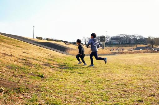 川原で元気に走る小学生の兄弟 川原で元気に走る小学生の兄弟 子供,兄弟,兄の写真素材