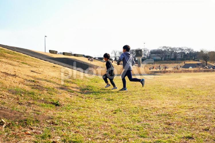 川原で元気に走る小学生の兄弟 子供,兄弟,兄の写真素材