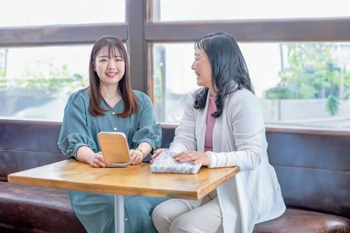 カフェで会話する二人の女性 カフェで会話する二人の女性 女性,笑顔,会話の写真素材