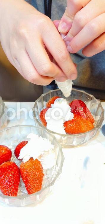生クリームを絞り出す手 苺,生クリーム,トッピングの写真素材