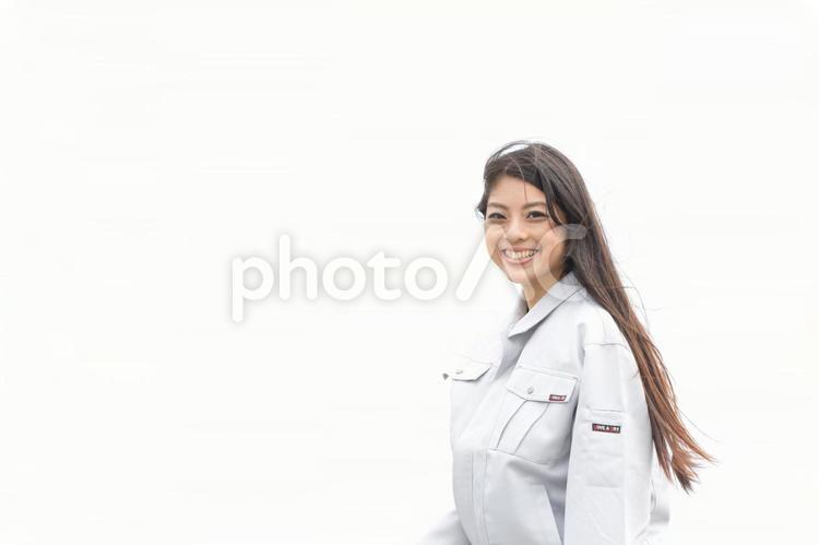 笑顔の作業着姿の若い女性（屋外）1 作業服,女性,日本人の写真素材
