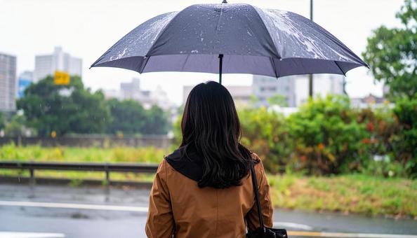 雨の中バス停でバスを待つ日本人女性 雨の中バス停でバスを待つ日本人女性の写真