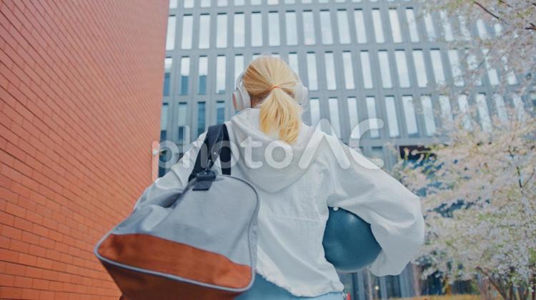 タイルの横を歩くボールを持ったシニア女性の後ろ姿 女性,人物,元気の写真素材