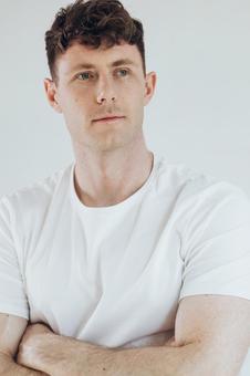 腕組みをして遠くを見る男性（白背景） 男性,外国人,欧米人の写真素材