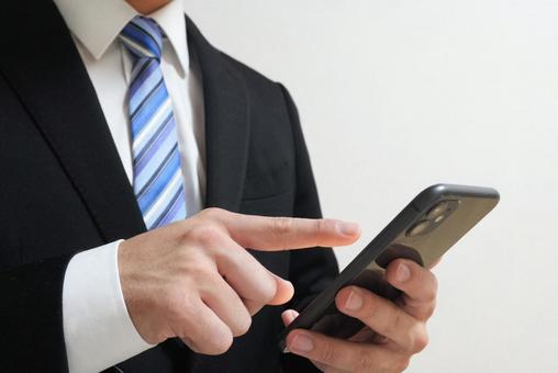 スマホを操作するビジネスマンのイメージ① スマホを操作するビジネスマンのイメージ① スマホ,スマートフォン,iphoneの写真素材