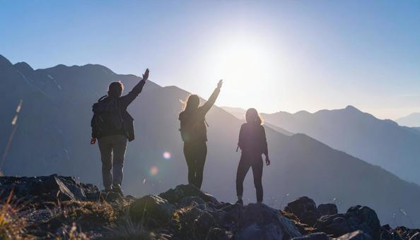 夏山で朝日に向かって手をあげる登山者 夏山で朝日に向かって手をあげる登山者の写真