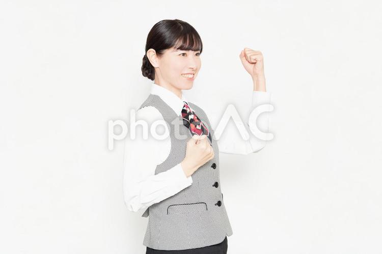 白い背景の前に立ってガッツポーズをするビジネスウーマン ガッツポーズ,女性,受付の写真素材