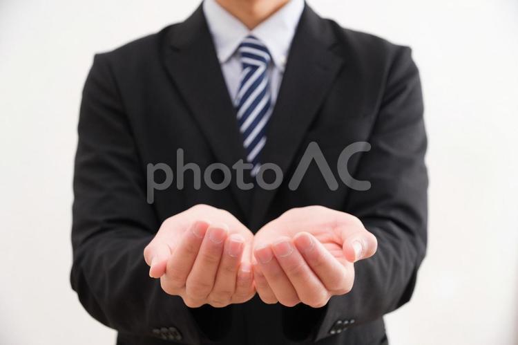 両手を前に出すスーツを着た男性 ポイント,案内,説明の写真素材