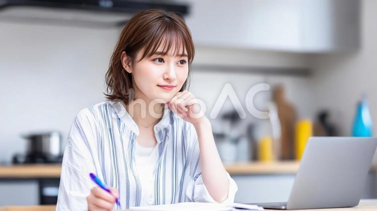 ノートPCでレシピを調べメモしている女性 ノートパソコン,女性,レシピの写真素材