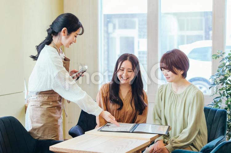 メニューを選ぶ客とカフェスタッフ カフェ,メニュー,注文の写真素材