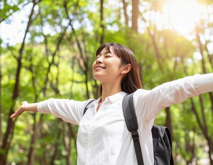 森林の中でリフレッシュする女性の写真