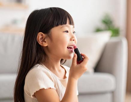 リップクリームを塗る女児 リップクリームを塗る女児の写真