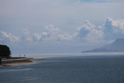 雲の夏空と青い海と海岸沿いの道と陸の風景 雲の夏空と青い海と海岸沿いの道と陸の風景の写真