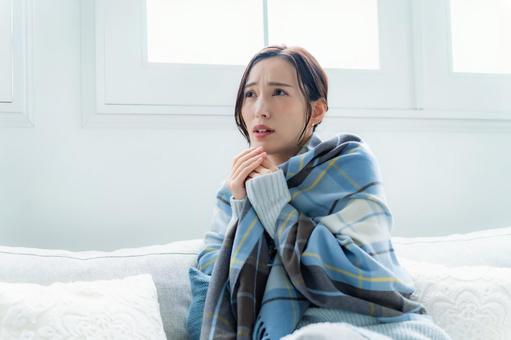 ソファに座る女性 疲労,咳,体調管理の写真素材