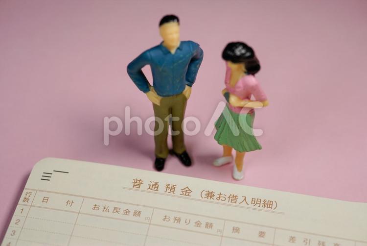 普通預金の通帳と男女 預金,普通預金,住宅ローンの写真素材
