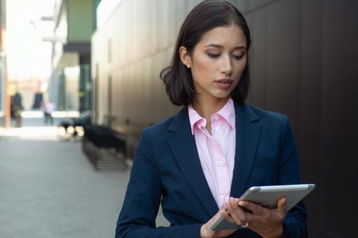 街なかでタブレット使うビジネスウーマン ビジネスウーマン,ビジネス,女性の写真素材