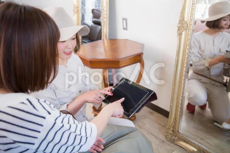 美容室でタブレットを指さす女性 タブレットpc,タブレット,美容室の写真素材