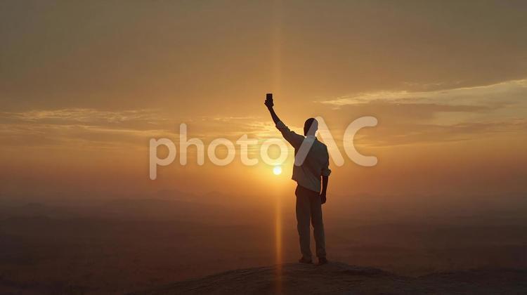 自由と達成感の瞬間 男性,シルエット,夕焼けの写真素材