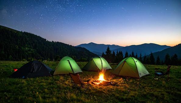 夜の星空の下の焚き火とテントキャンプ 夜の星空の下の焚き火とテントキャンプの写真