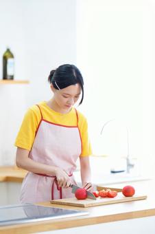 真剣な顔でトマトを切っている女性 女性,トマト,切るの写真素材