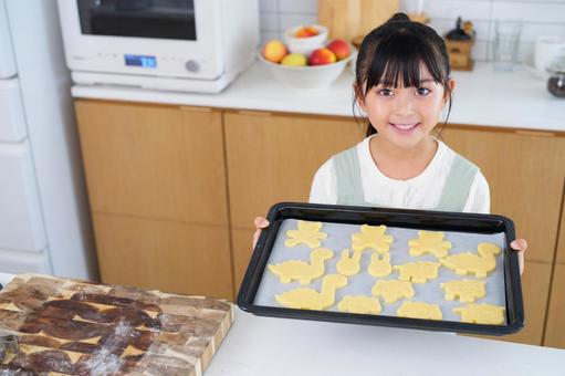 焼く前のクッキーを持って笑顔を見せる女の子 女の子,日本人,クッキーの写真素材