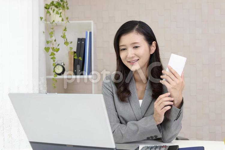 スマートフォンを持つ笑顔のビジネスウーマン 女性,ビジネスウーマン,女の写真素材