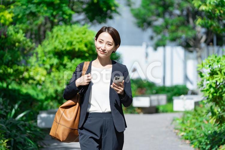 携帯を持つスーツを着た女性 スーツ,人物,会社員の写真素材