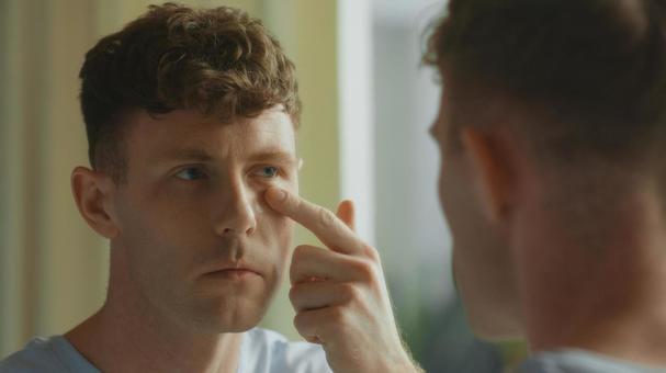 洗面所の鏡で目元を見る男性 男性,外国人,欧米人の写真素材